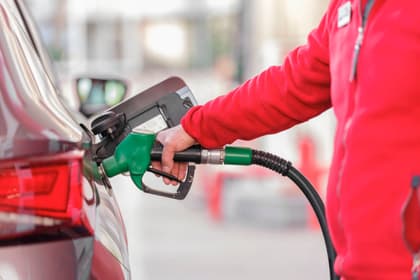 Operator de stație alimentând un autoturism cu pistolul pompei